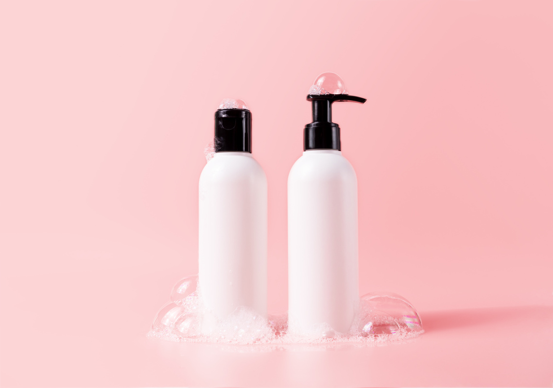 Shampoo and Hair Conditioner Bottles with Soapy Bubbles